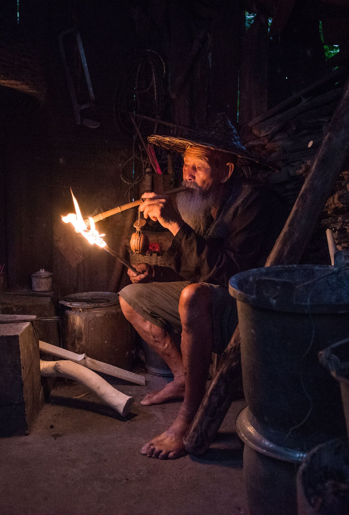 A senior Cormorant fisherman smoking an improvised cigar